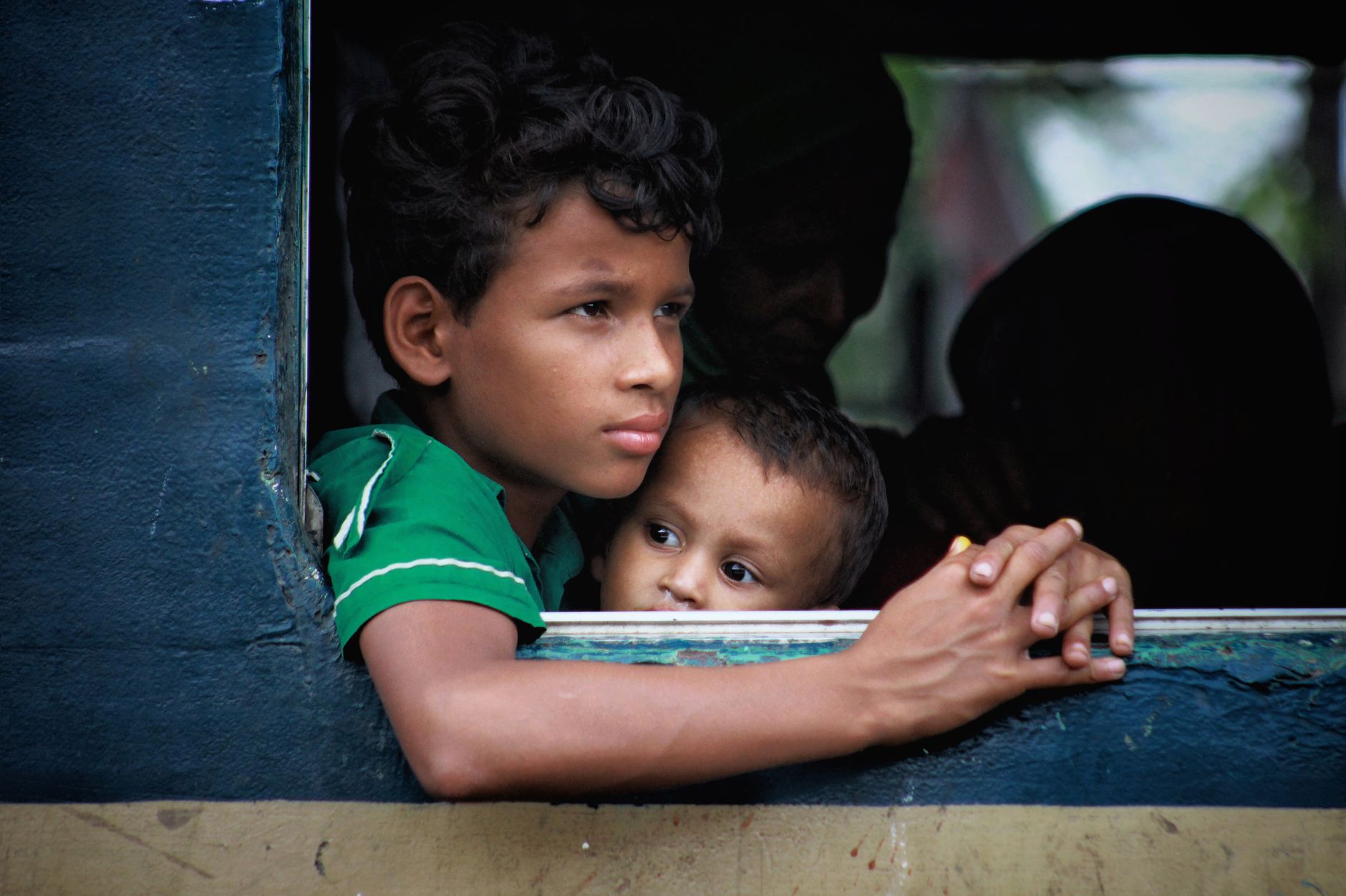 Two young boys looking out of a train window, experiencing a travel journey.
