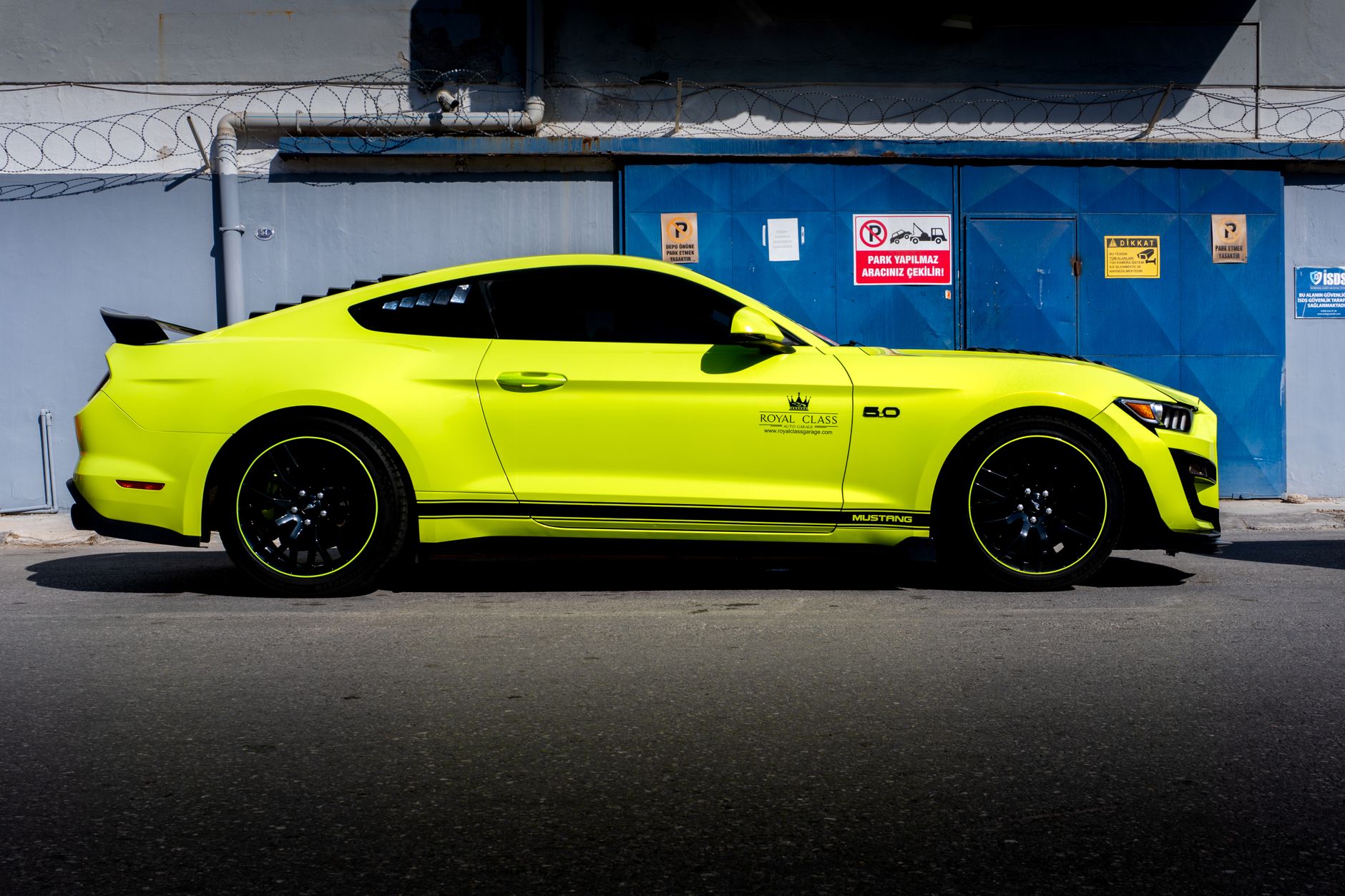 A sleek yellow sports car parked against an industrial backdrop in Türkiye.