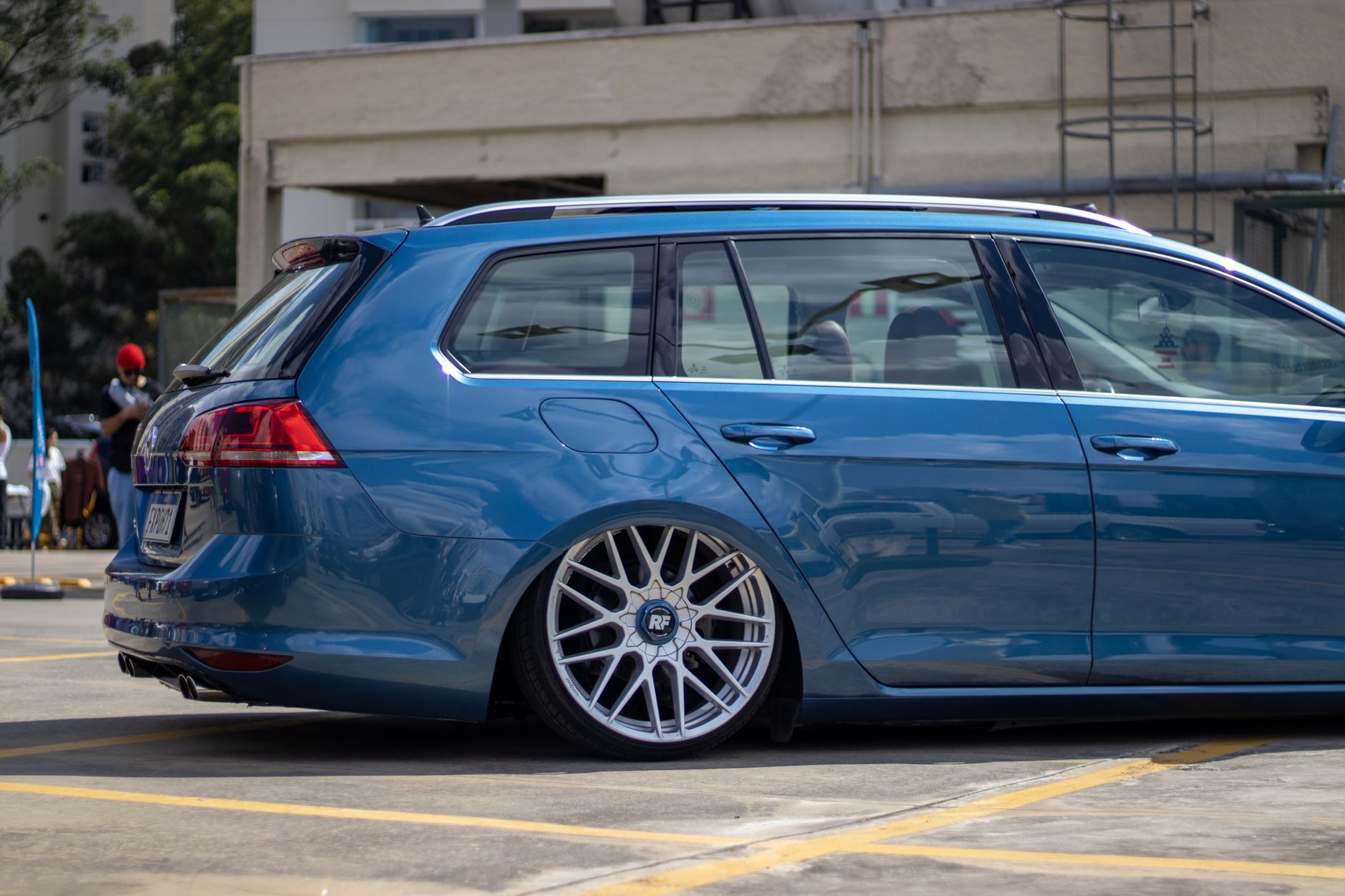 A sleek blue station wagon parked outdoors during the day, capturing reflective surfaces and stylish wheels.