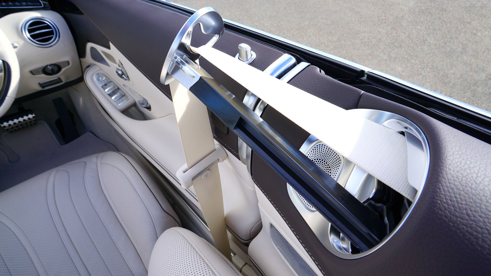 Close-up view of a luxury car interior featuring beige leather seats and modern design elements.
