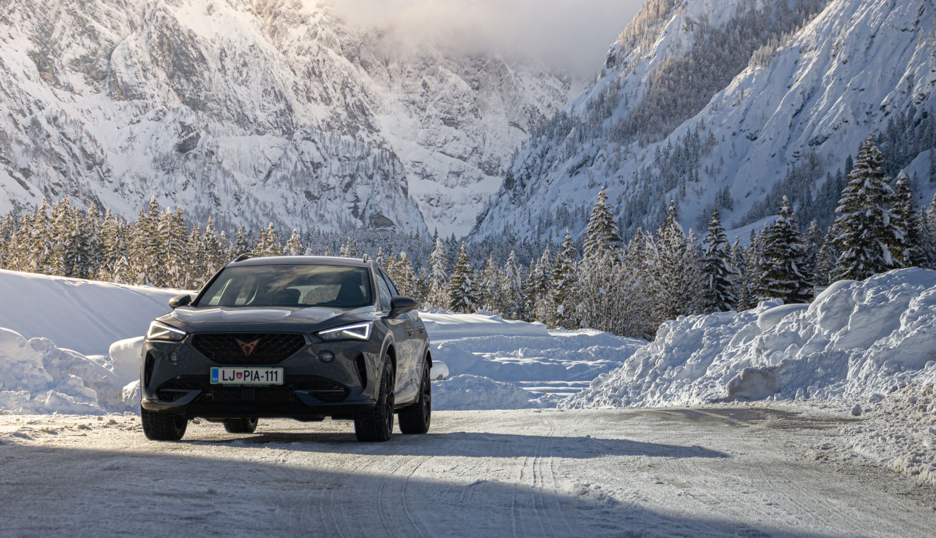 Cupra Formentor driving through snow-covered mountain road in Jesenice, Slovenia.