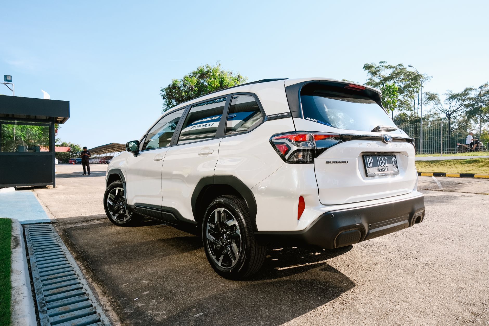 A sleek white SUV parked in a sunny outdoor area, showcasing its modern design and features.