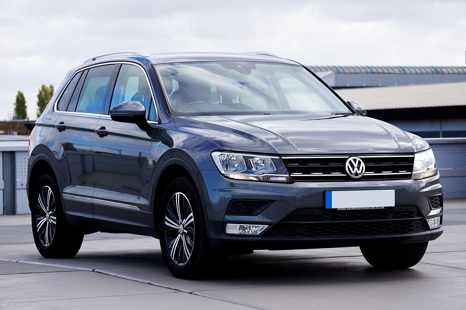 A sleek gray Volkswagen Tiguan SUV parked in an urban environment, perfect for city travel and lifestyle imagery.