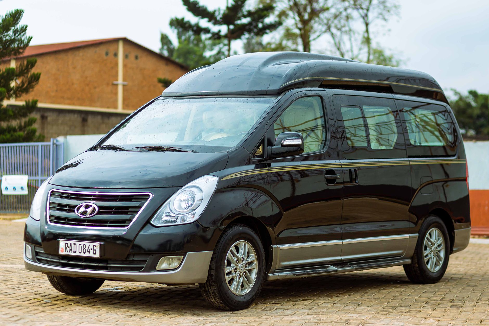 Black Hyundai van parked outdoors on pavement on a clear day.