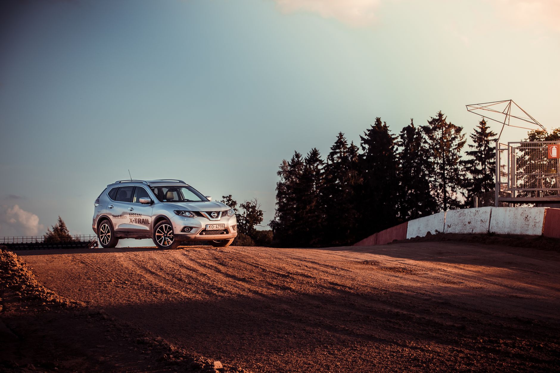 A Nissan SUV parked on a dirt road, capturing the essence of adventure and nature at sunset.