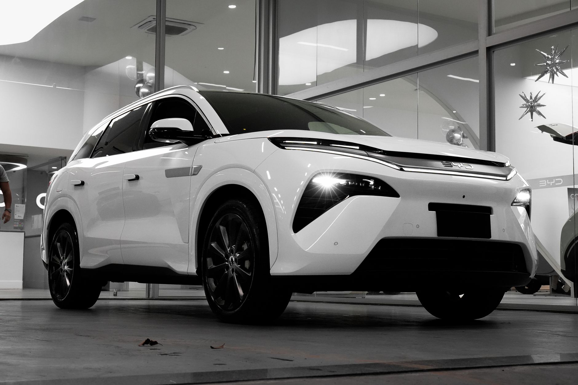 Sleek white electric SUV showcased in a modern indoor showroom. Perfect for automotive enthusiasts.