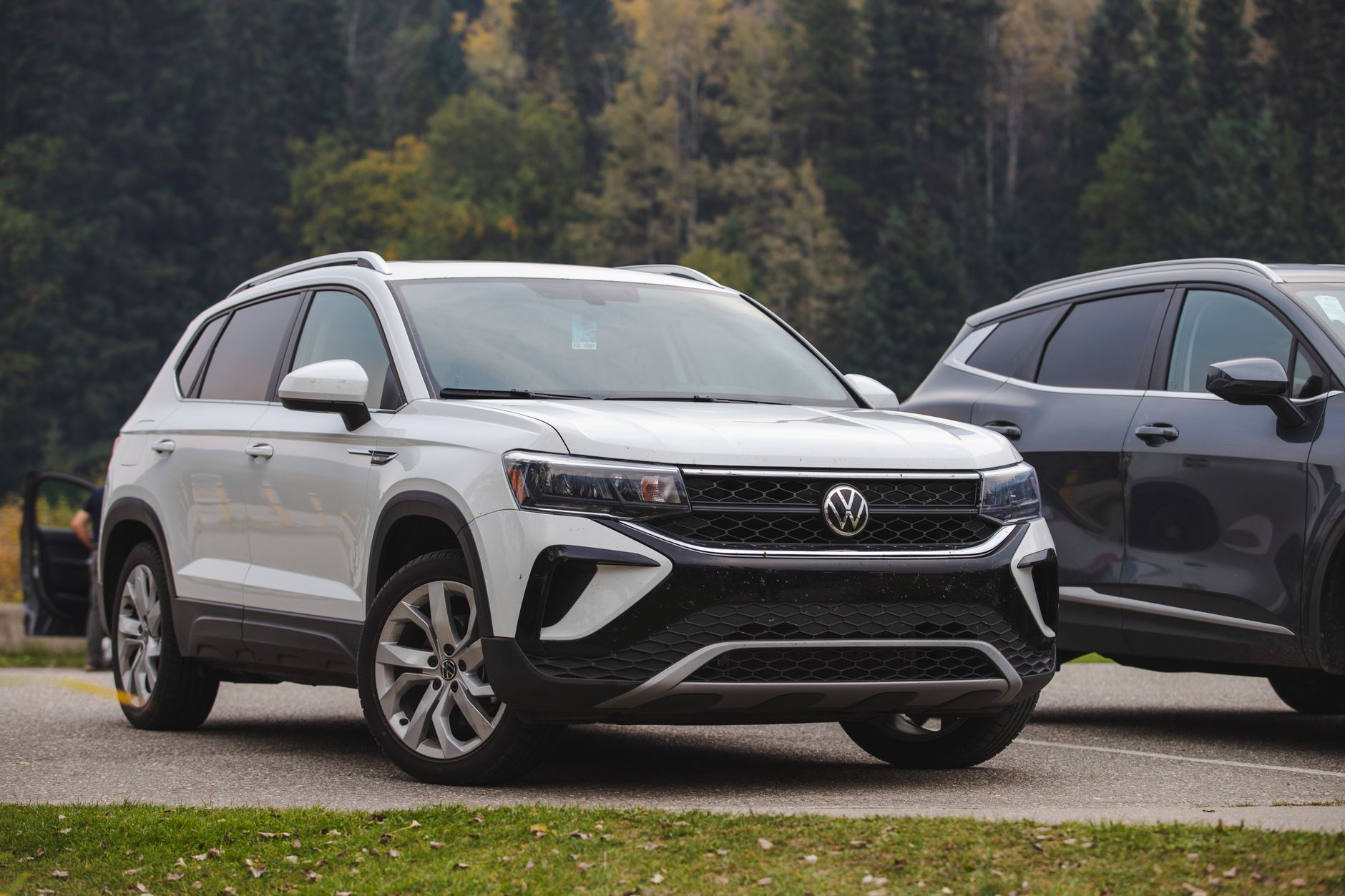 White Volkswagen compact SUV parked outdoors in a scenic forest setting.