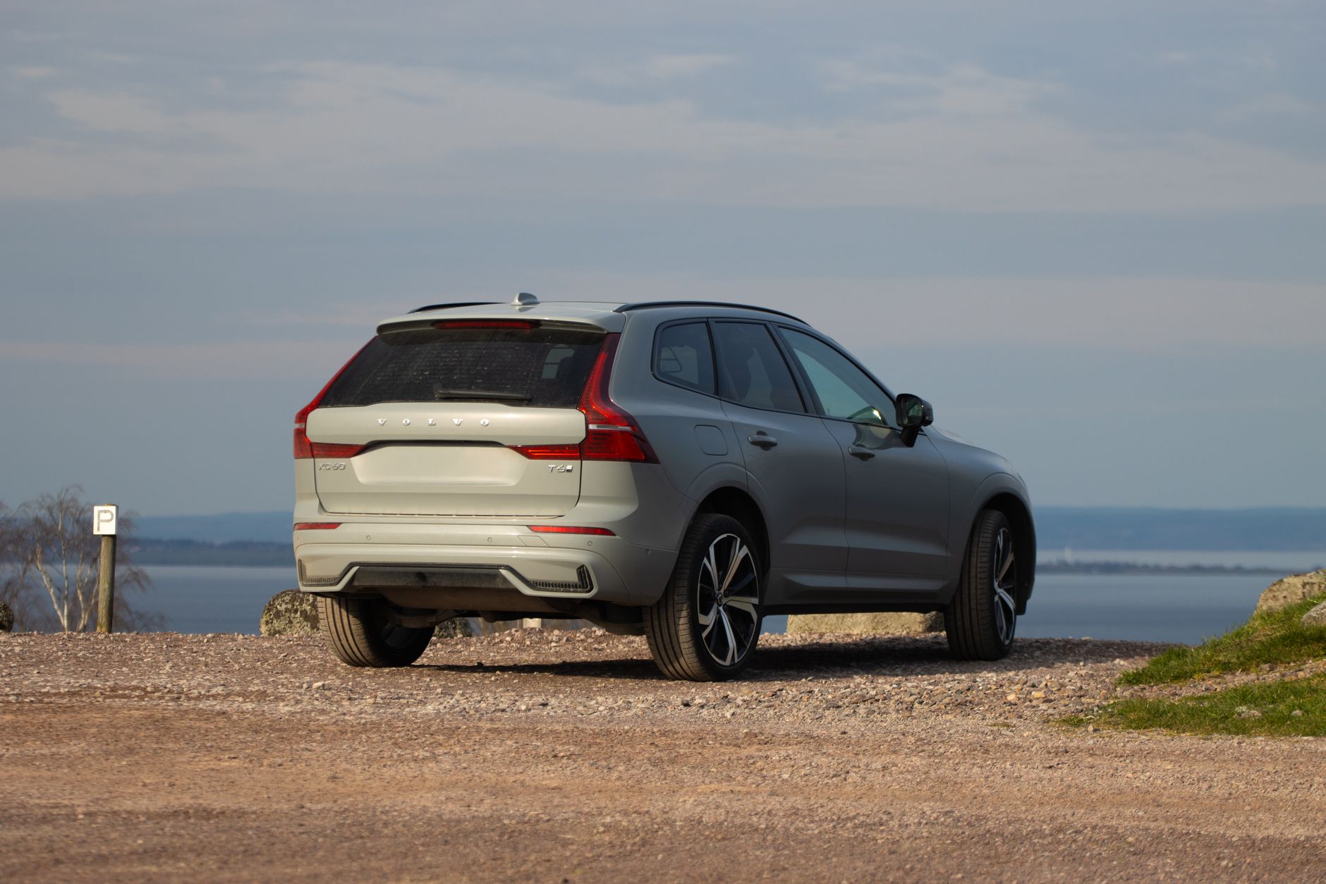 Volvo XC60 parked on a scenic hilltop overlooking a lake in Sweden, capturing autumn vibes.