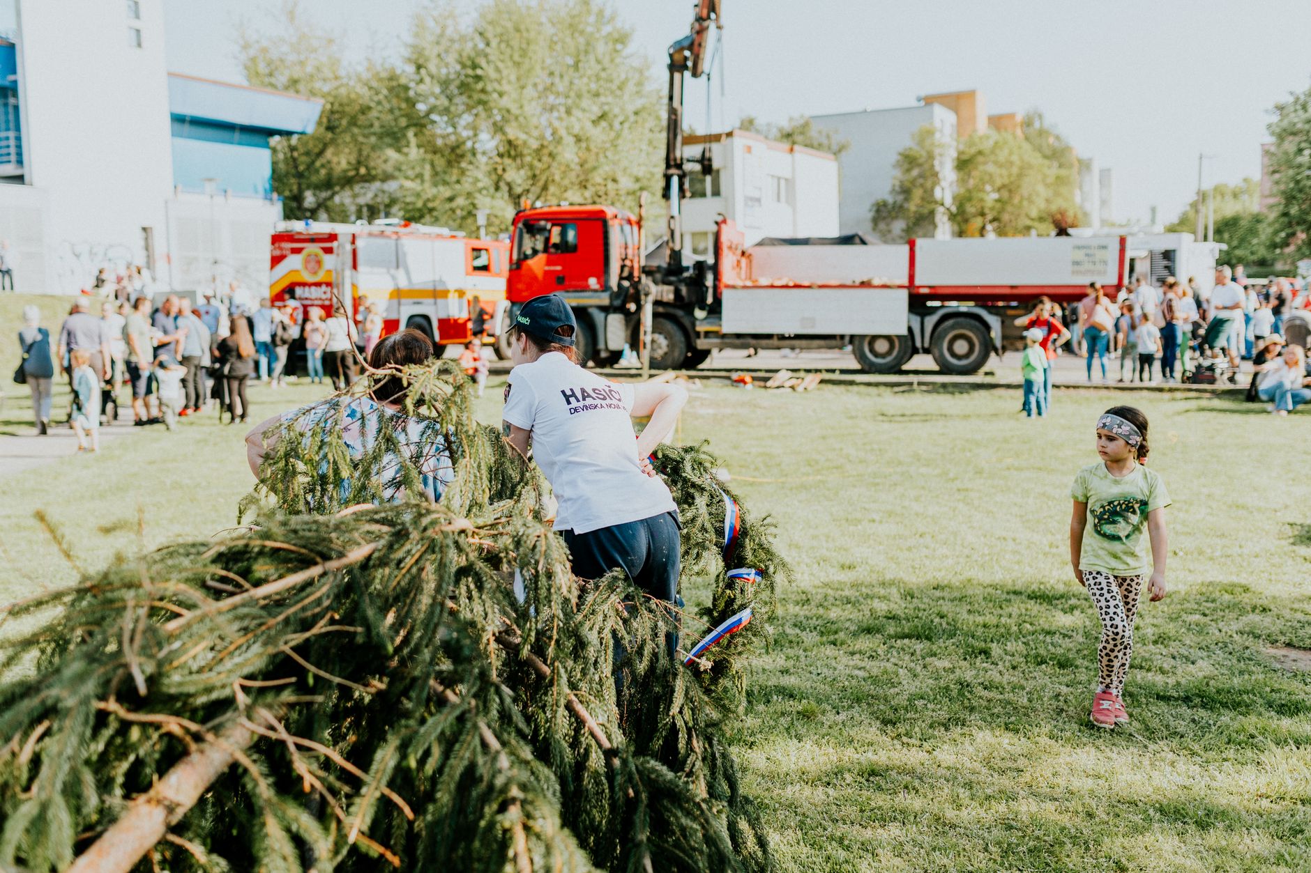 A lively outdoor community event featuring fire trucks, families, and a festive atmosphere.