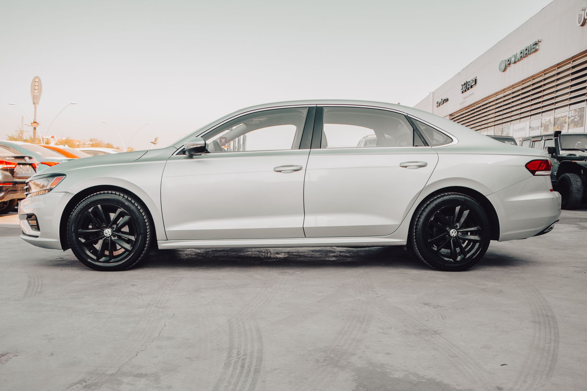 Side view of a silver Volkswagen Passat parked in a showroom in Erbil, capturing the sleek design.