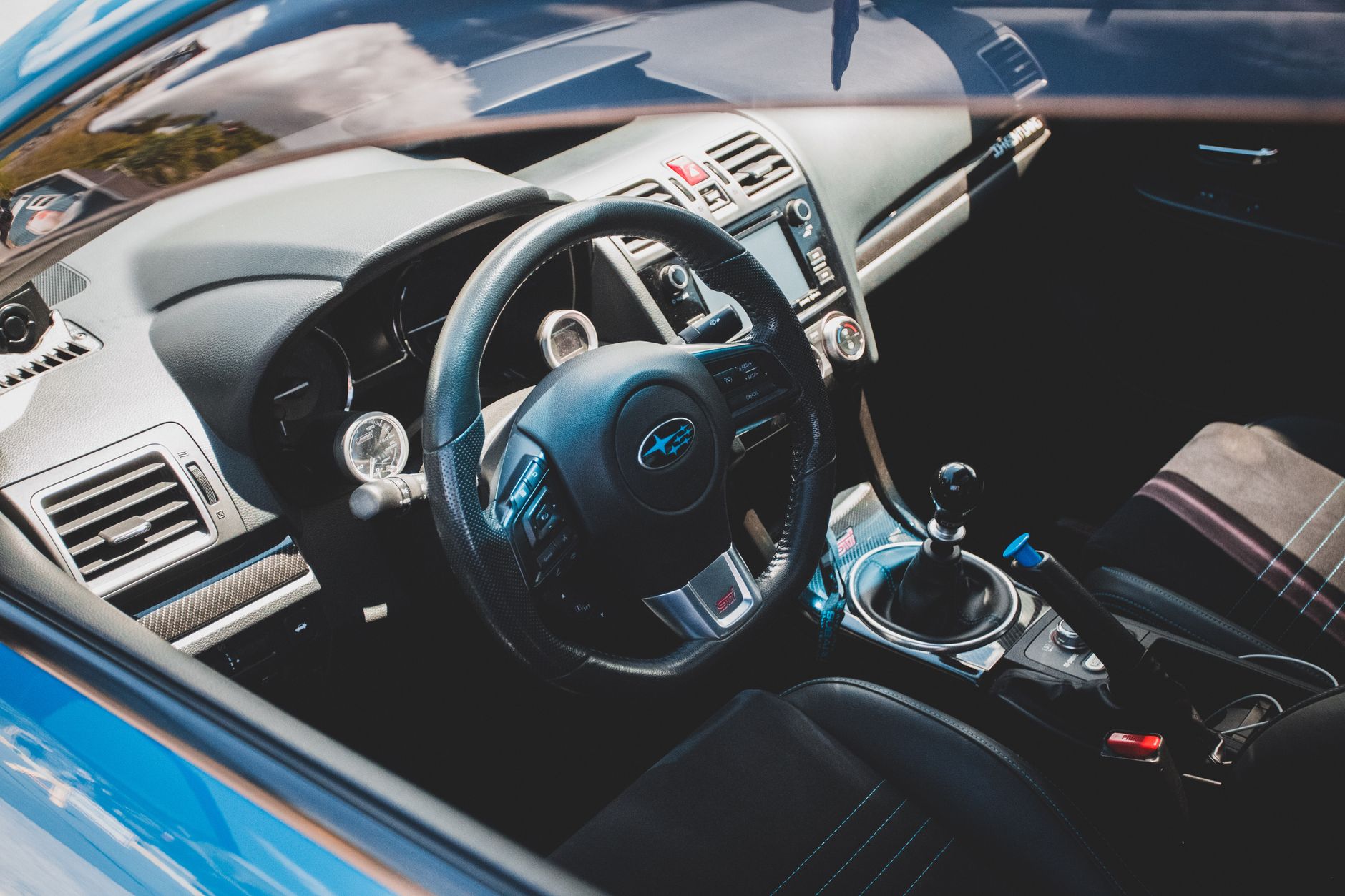A clean and modern car interior showcasing a steering wheel and manual gear shift.